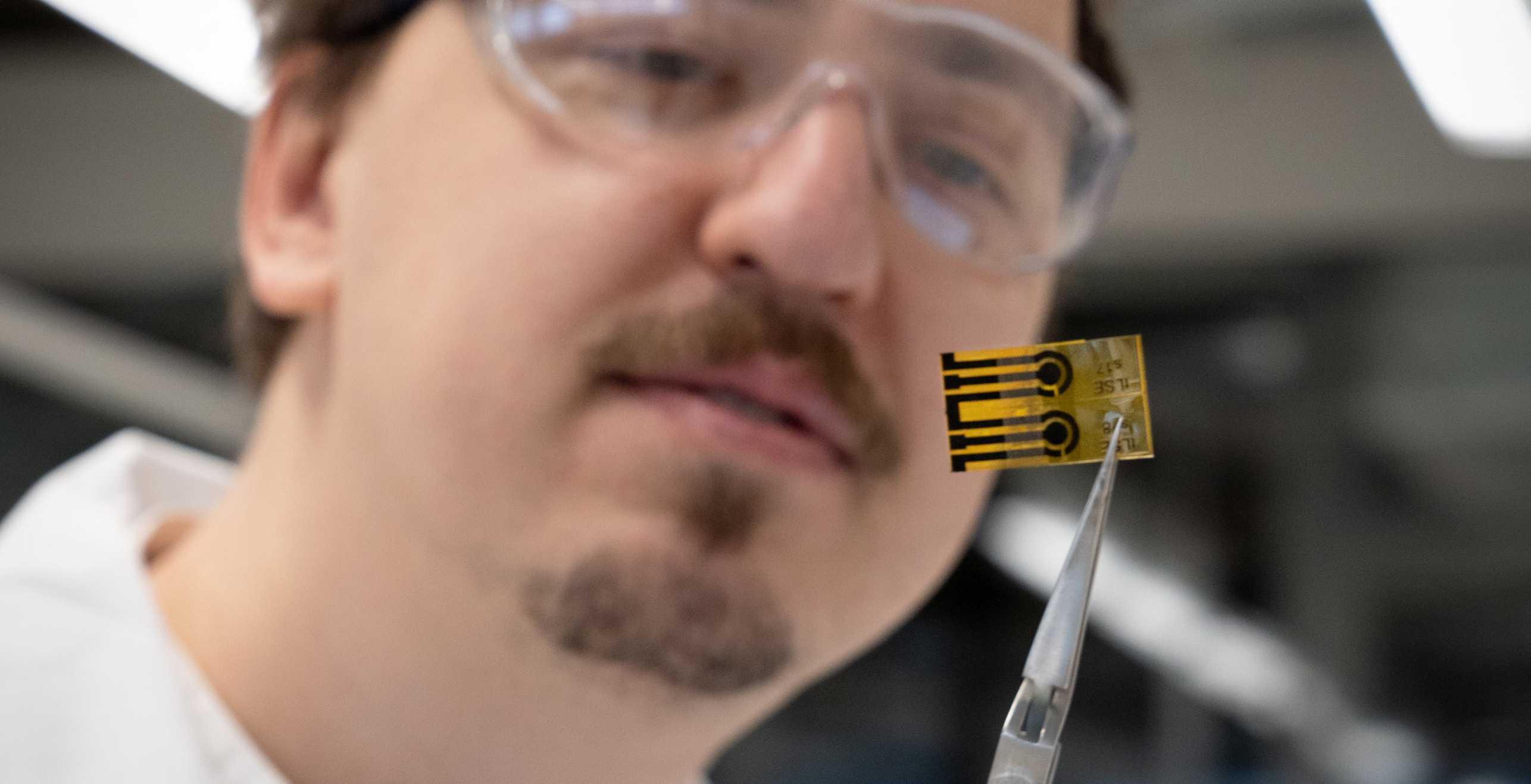 BMHT Postdoc Alexander Shokurov holding a laser scribed graphene electrochemical sensor.